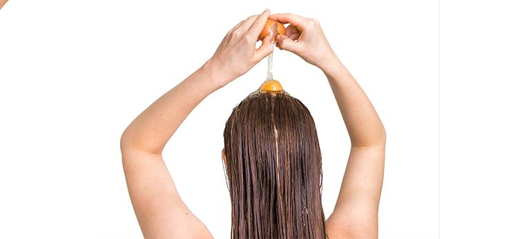 attractive-woman-applying-egg-conditioner-on